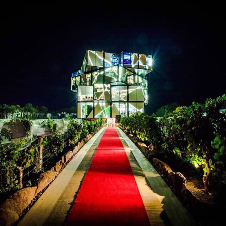 Modern cube building with a red carpet in a vineyard