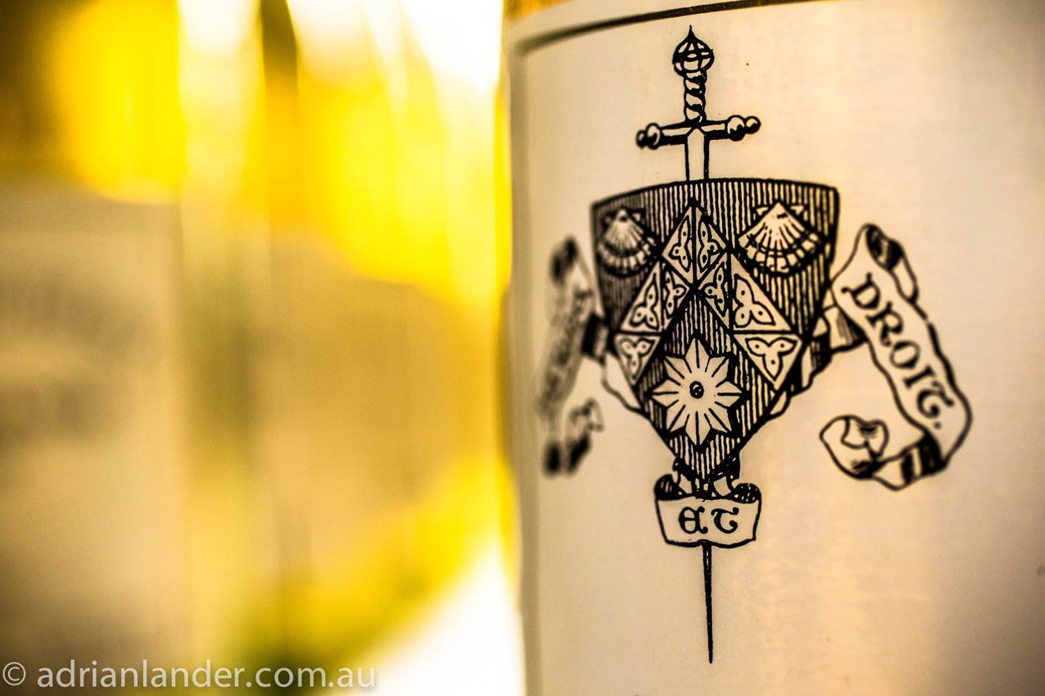 artful image of white wine in glass and bottle label