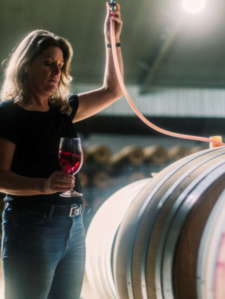 woman works with wine in a barrel