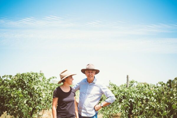 two people stand in vineyard